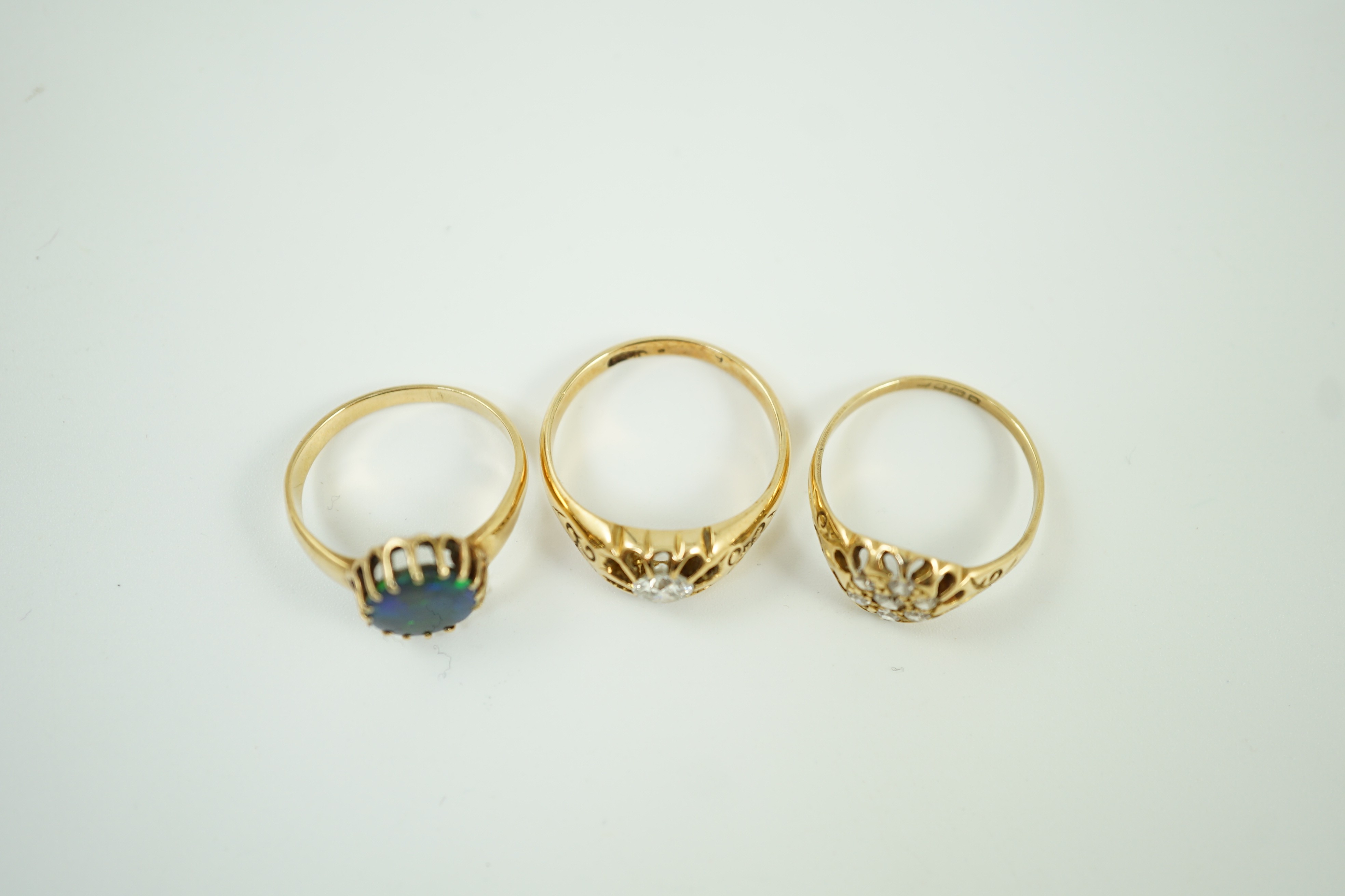 An early 20th century 18ct gold and diamond cluster ring, size P/Q, gross weight 3.1 grams and two other yellow metal rings including claw set solitaire diamond ring, size Q, gross weight 9.1 grams(2).